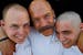 Brotherhood of Bald People founder and mission director Mike Ubl, center, hugged sons Tyris Ubl, 20, left and Alex Pearson, 20, after they had their h