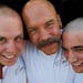 Brotherhood of Bald People founder and mission director Mike Ubl, center, hugged sons Tyris Ubl, 20, left and Alex Pearson, 20, after they had their h