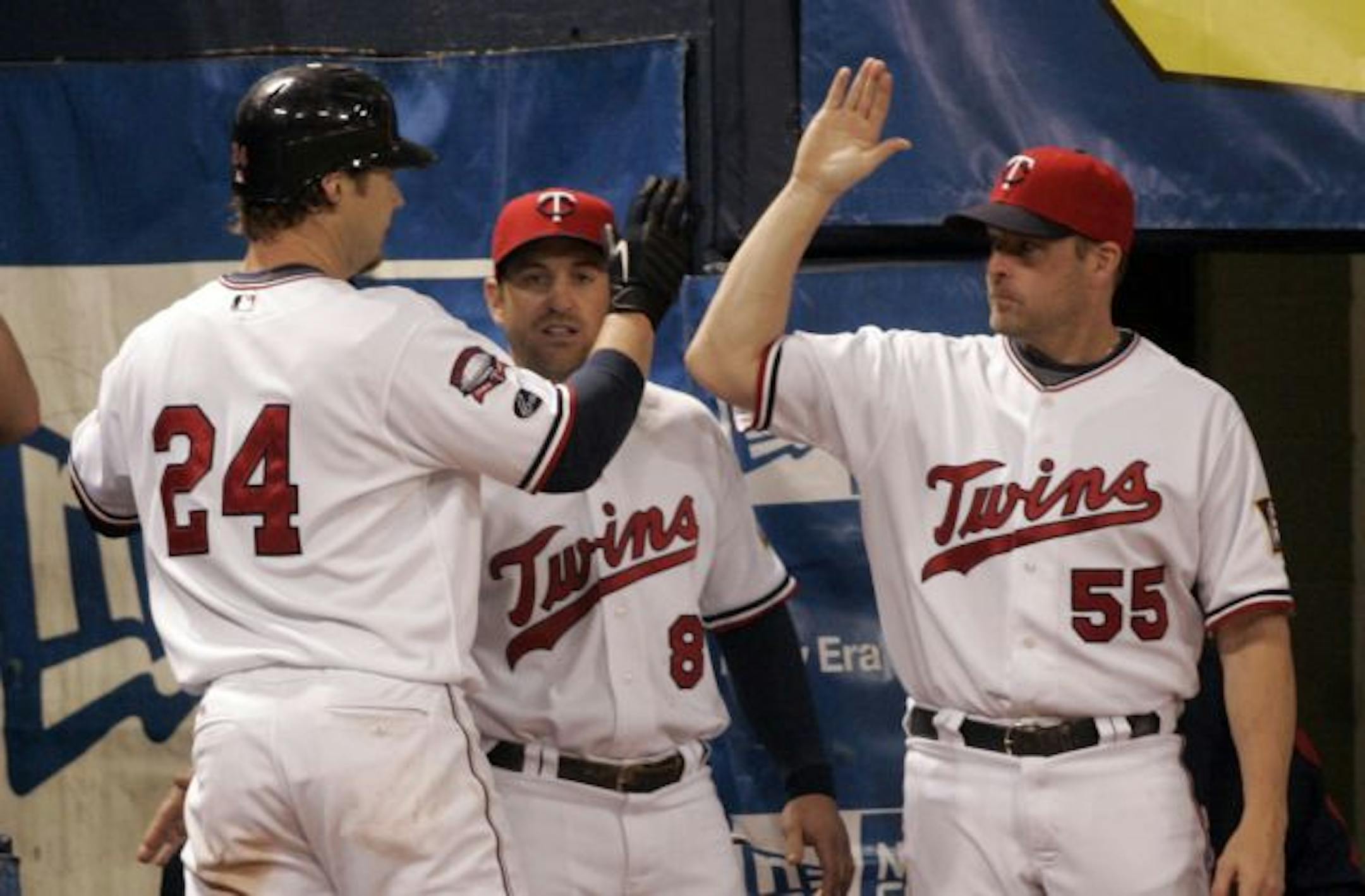 Minnesota Twins Joe Crede, left to right, is greeted by Nick Punto and Mike Redmond after hitting a solo homerun during the 4th inning of the Twins game against the Milwaukee Brewers at the Metrodome.
