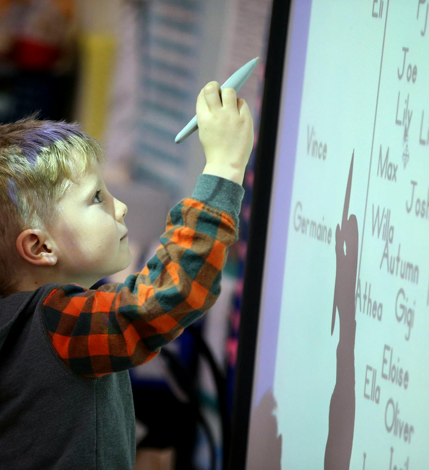 Meadowbrook Elementary School kindergarten student Vince Gallo uses a stylus to move his name on a computer screen during attendance in Kristin Koloski's class Wednesday, Oct. 19, 2016, in Golden Valley, MN.