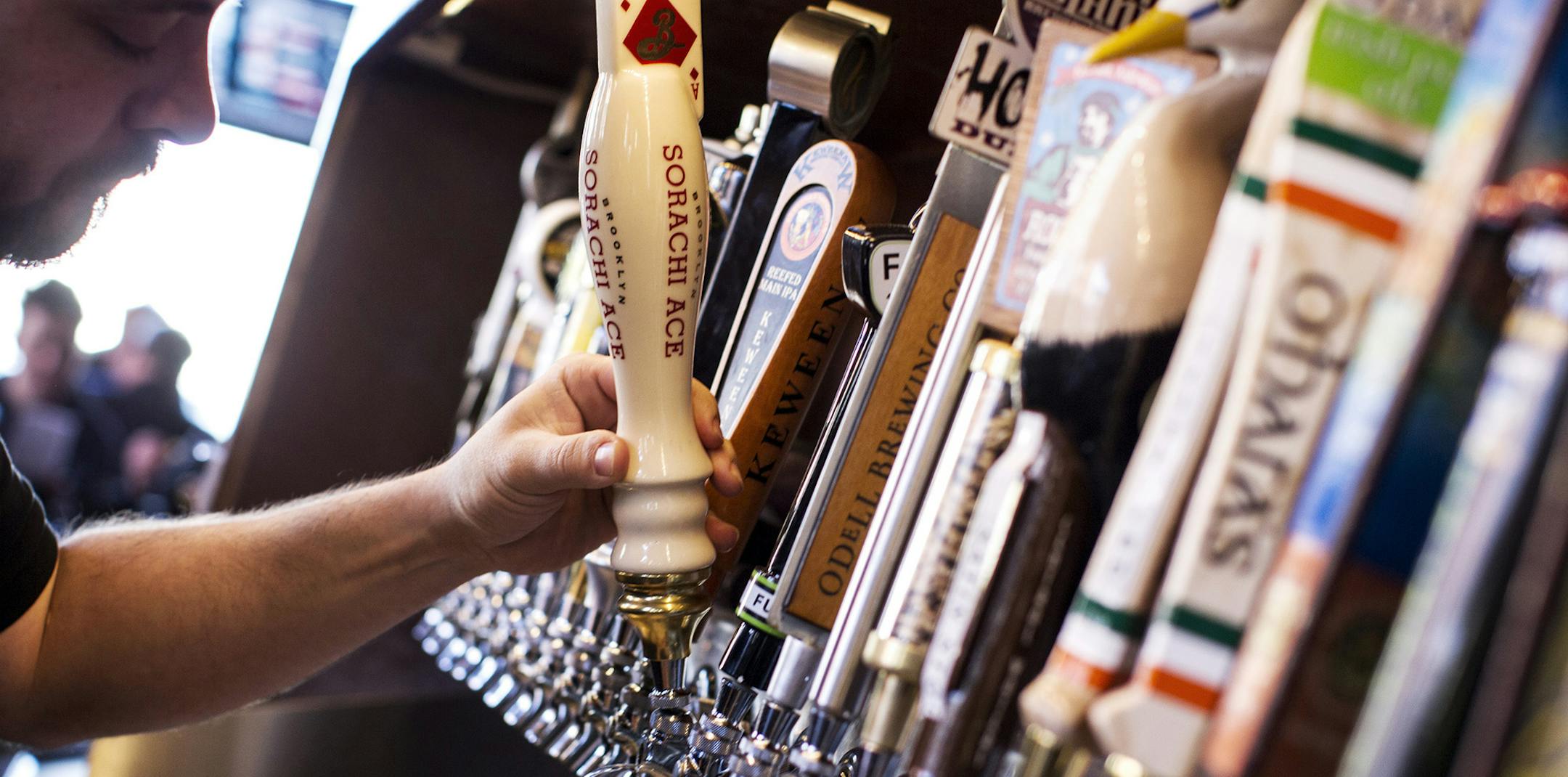 Eric Hellzen draws a beer from one of the 76 taps at The Happy Gnome in St. Paul March 15, 2014. (Courtney Perry/Special to the Star Tribune)