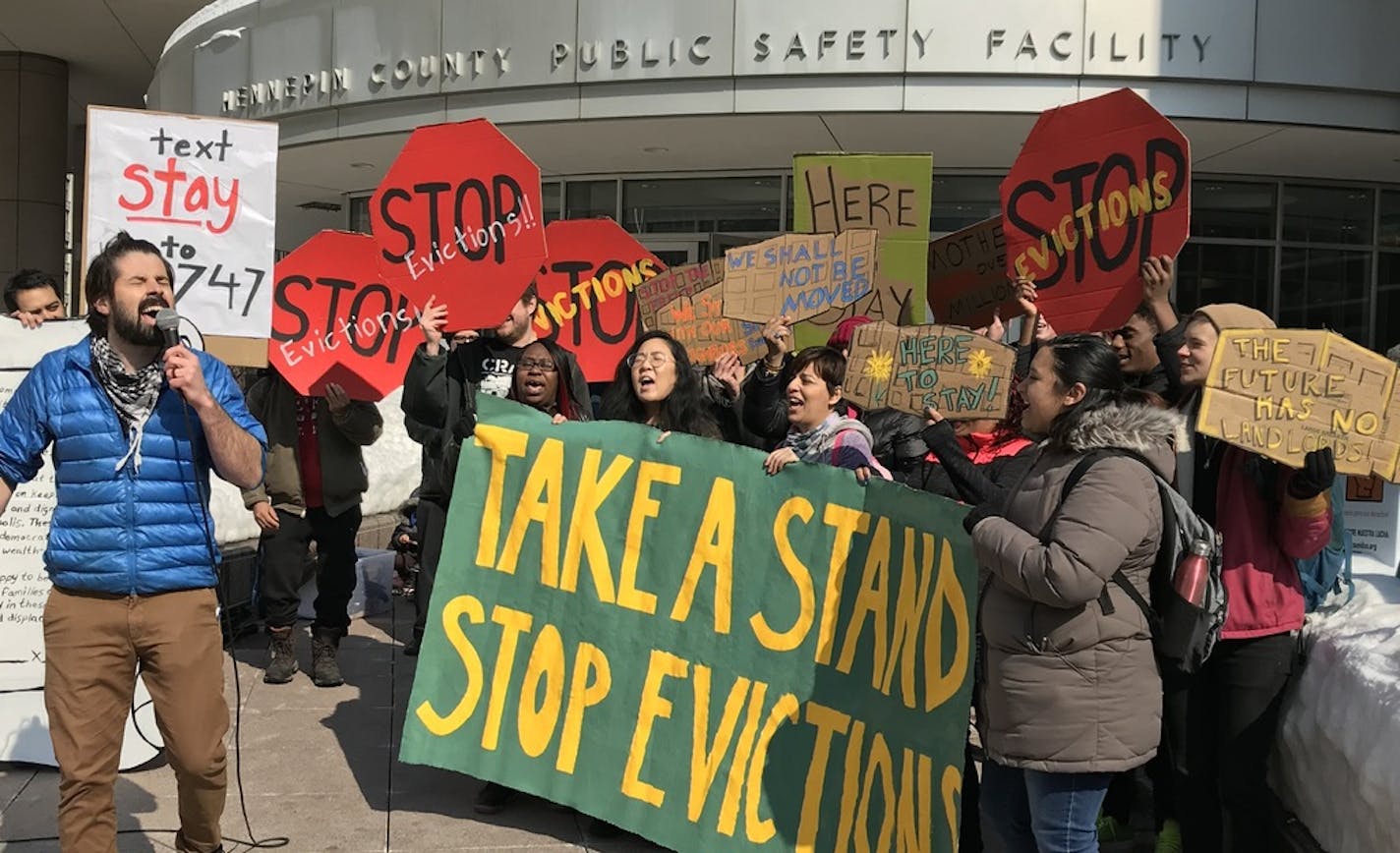 Tenants organizer Roberto de la Riva of United Renters for Justice leads tenants of landlord Stephen Frenz in a chant outside the Hennepin County Public Safety Facility, where Frenz made his first court appearance on felony perjury charges. (Photo by Randy Furst)