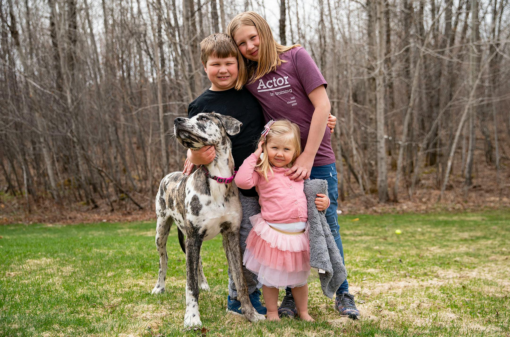 Leo, 8, Ada, 2, and Elsie Sather, 9, posed for a portrait with their puppy, Una. They all have their own unique ways of coping with being stuck at home including broadway musicals, stuffed animals and playing with their dog.
