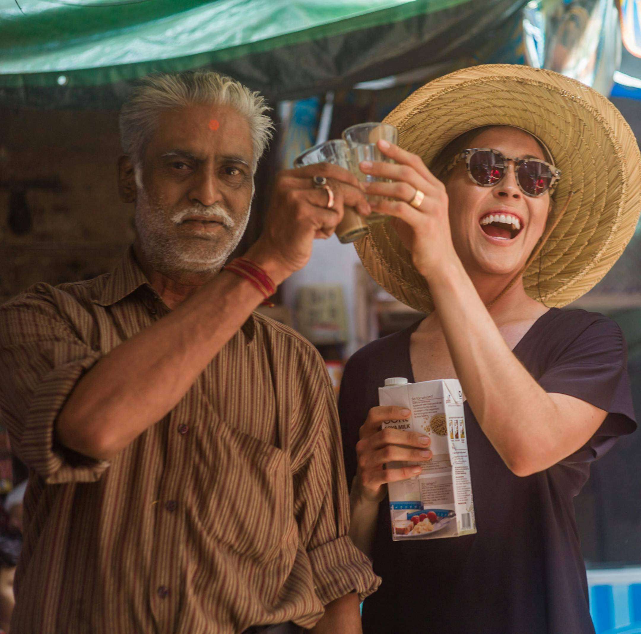 A traveler with Intrepid Travel and a vendor enjoy vegan chai tea.