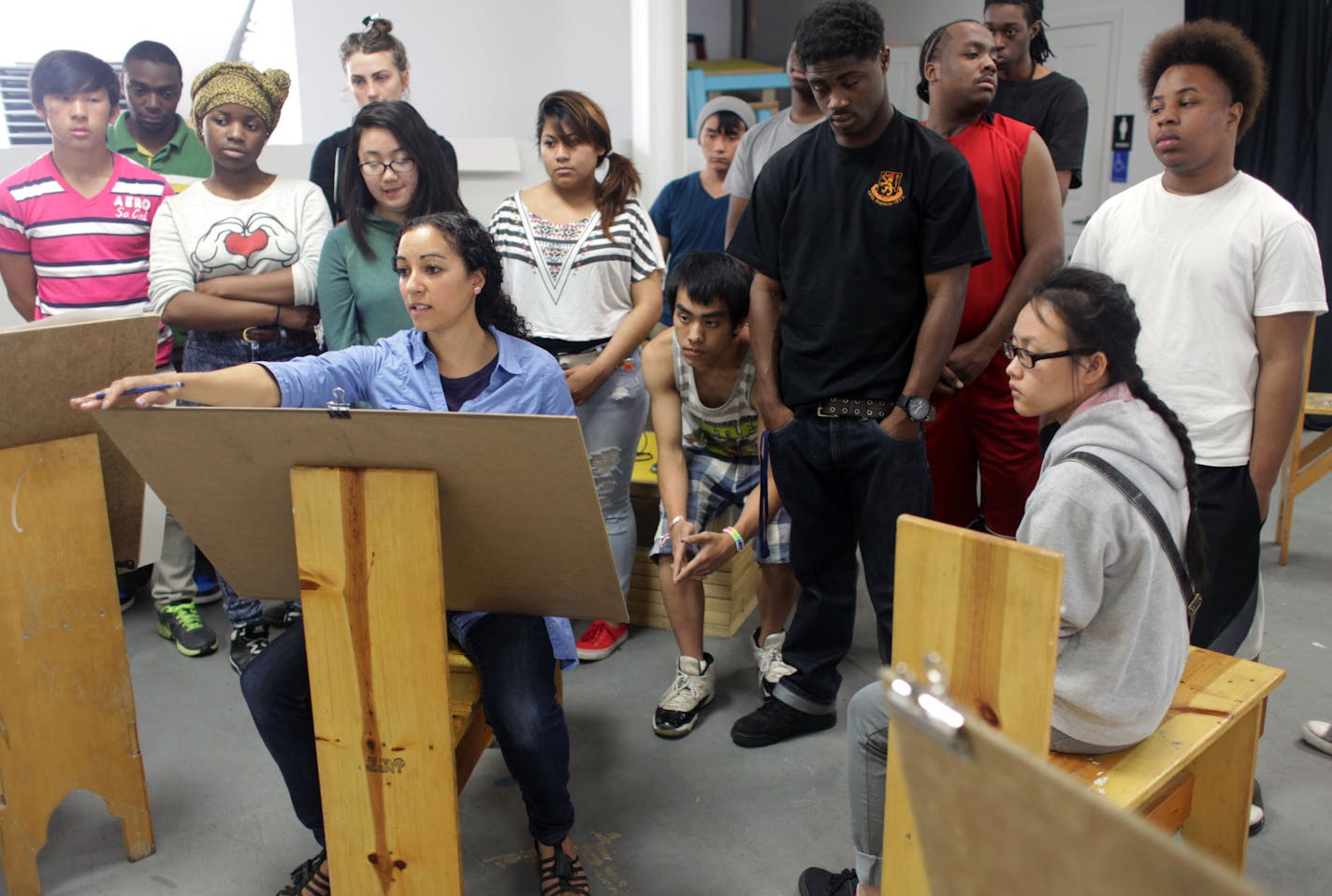 Caroline Kent demonstrates still life drawing during an art class at Juxtaposition Arts in Minneapolis, a nonprofit that offers a youth-run graphic design business. The nonprofit won a recent Bush prize for its innovative work. .] MONICA HERNDON monica.herndon@startribune.com Minneapolis, MN 06/11/2014