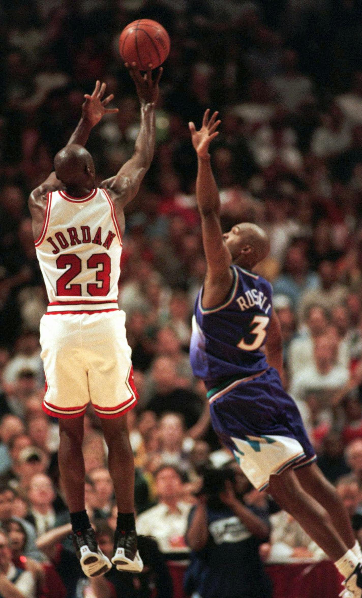 The Chicago Bulls' Michael Jordan puts up the game-winning shot over Utah Jazz forward Bryon Russell, right, to win Game 1 of the NBA Finals 84-82 Sunday, June 1, 1997, in Chicago. (AP Photo/Fred Jewell ) ORG XMIT: CXA121