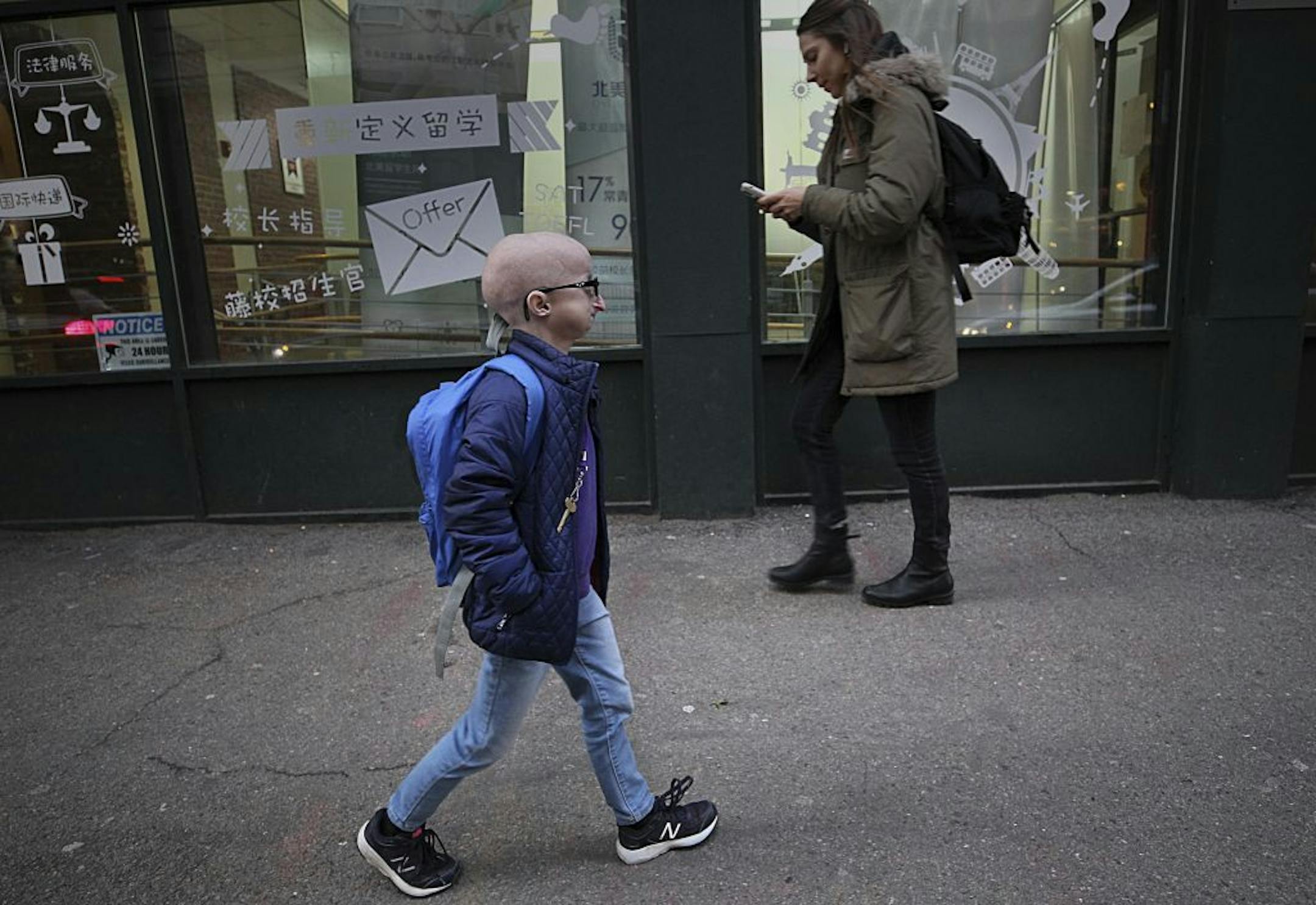 In this Feb. 12, 2019 photo, Meghan Waldron walks down the street in Boston. Waldron is a student at Emerson College with progeria, one of the world's rarest diseases. The first treatment has been approved for progeria, Friday, Nov. 20, 2020. The U.S. Food and Drug Administration on Friday approved Zokinvy which was shown in testing to extend patients' lives by 2 ½ years on average.