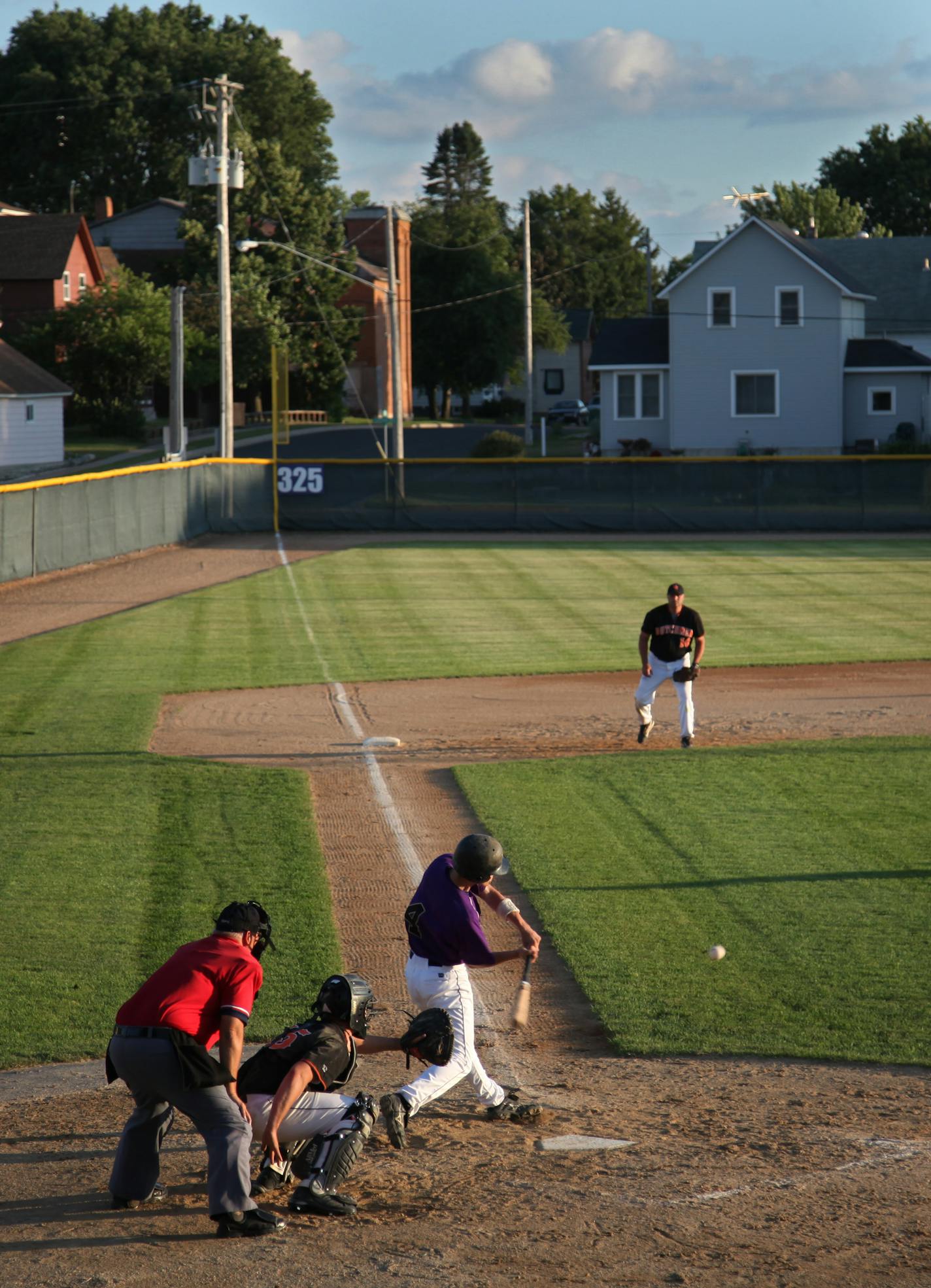 BRIAN PETERSON ¥ brianp@startribune.com Hamburg, MN 6/30/2009 ] The Hamburg Ballpark is tucked into the northern edge of the small town, between the beans and the modest homes that give it charm. Here, Hamburg Hawks #4 Justin Perlich gets a hit off the rivals from New Germany on a warm July evening in Central Minnesota.