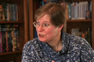 Lois McMaster Bujold at her home library in Edina. Behind her are some of her books, many of them are n different languages.