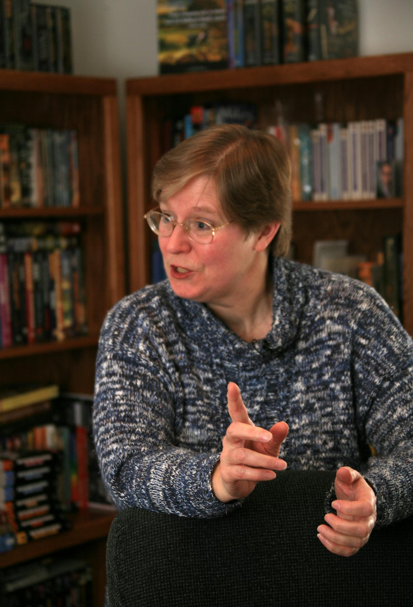 Lois McMaster Bujold at her home library in Edina. Behind her are some of her books, many of them are n different languages.