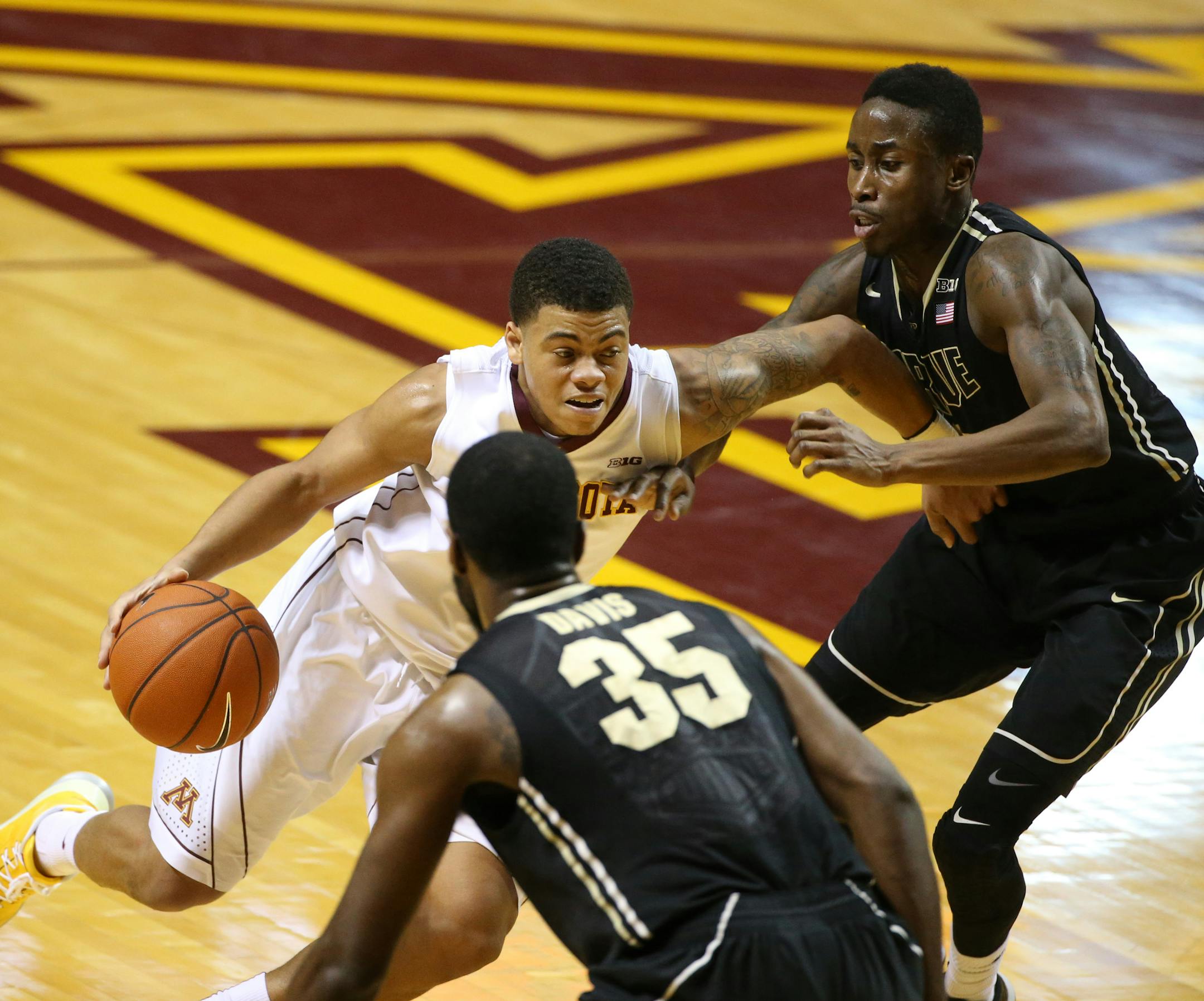 Minnesota's Nate Mason (2) is double teamed by Purdue's Jon Octeus, right, and Raheal Davis (35) during the first half Saturday, Feb. 7, 2015, at Williams Arena in Minneapolis.