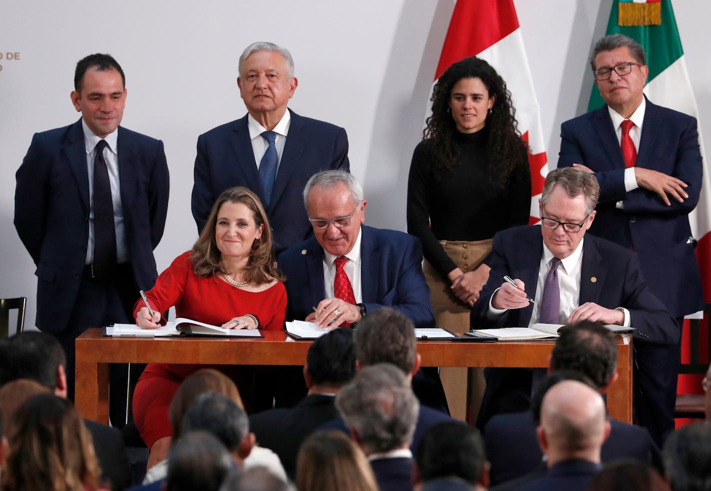 Deputy Prime Minister of Canada Chrystia Freeland, left, Mexico's top trade negotiator Jesus Seade, center, and U.S. Trade Representative Robert Lighthizer, sign an update to the North American Free Trade Agreement, at the national palace in Mexico City, Tuesday, Dec. 10. 2019. Observing from behind are Mexico's Treasury Secretary Arturo Herrera, left, Mexico's President Andres Manuel Lopez Obrador, second left, Mexico's Labor Secretary Maria Alcade, third left, and The President of the Mexican