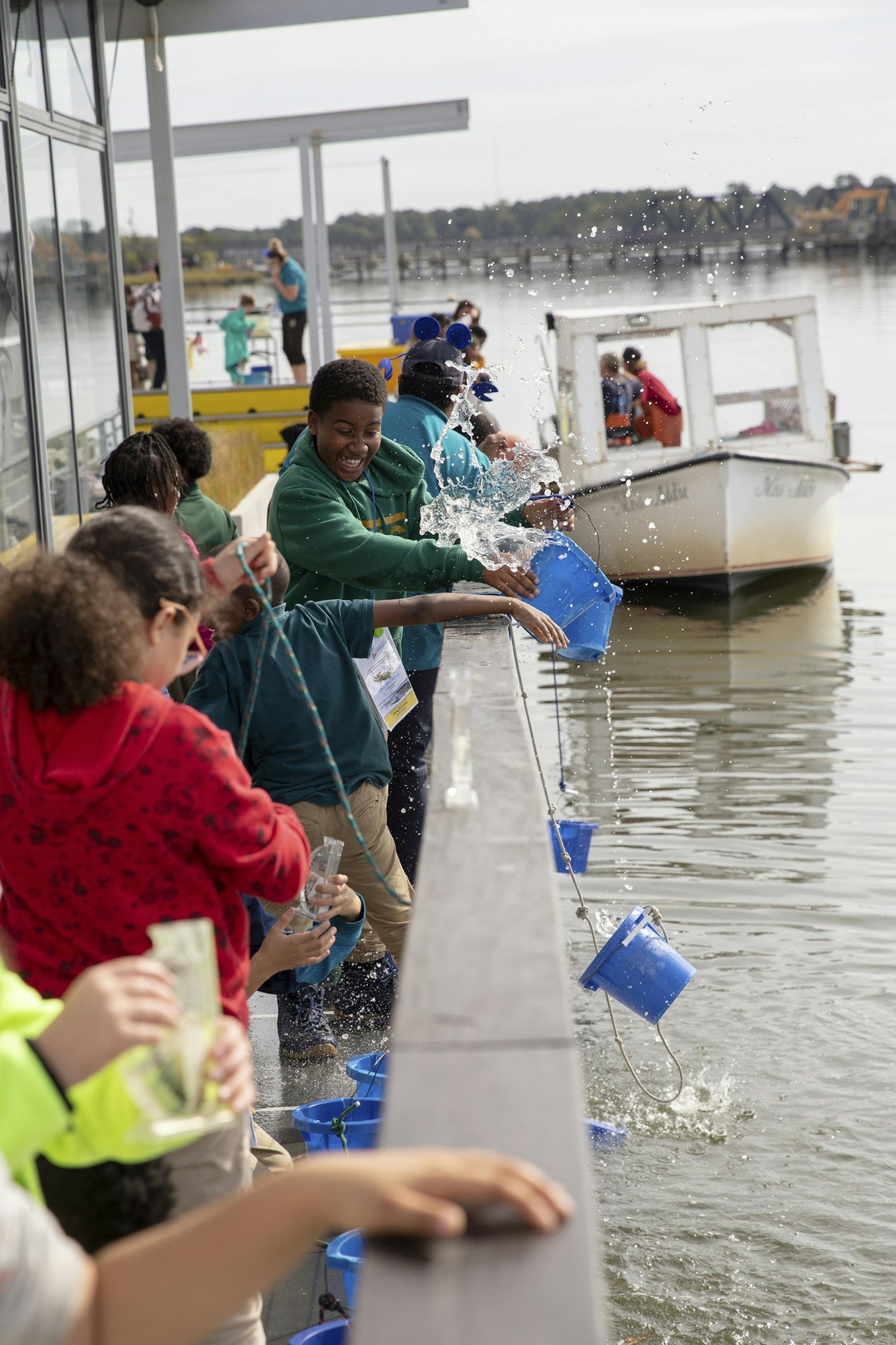 Fourth grader Chance Fleetwood gets splashed while testing water salinity on the Learning Barge in Norfolk, Va., Oct. 25, 2019. Federally funded programs use games, gardens and rain barrels to empower adults and children facing threats like sea-level rise, drought, flooding, extreme heat and severe storms. (Parker Michels-Boyce/The New York Times)
