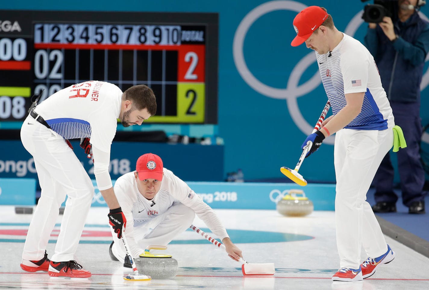 United States's skip John Shuster, center, throws a stone as teammates John Landsteiner, left, and Matt Hamilton prepare to sweep the ice during a men's curling match against South Korea at the 2018 Winter Olympics in Gangneung, South Korea, Wednesday, Feb. 14, 2018. (AP Photo/Natacha Pisarenko)