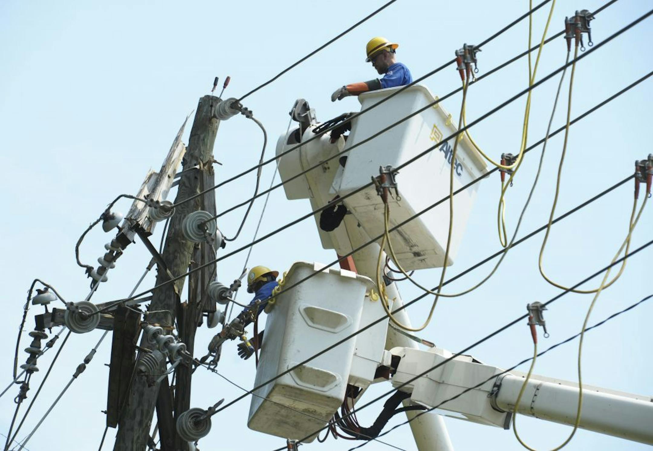 Utility workers secure power lines on a pole in Springfield, Va., Sunday, July 1, 2012. A severe storm late Friday knocked out power to approximately one million residents, traffic signals and businesses in the region.