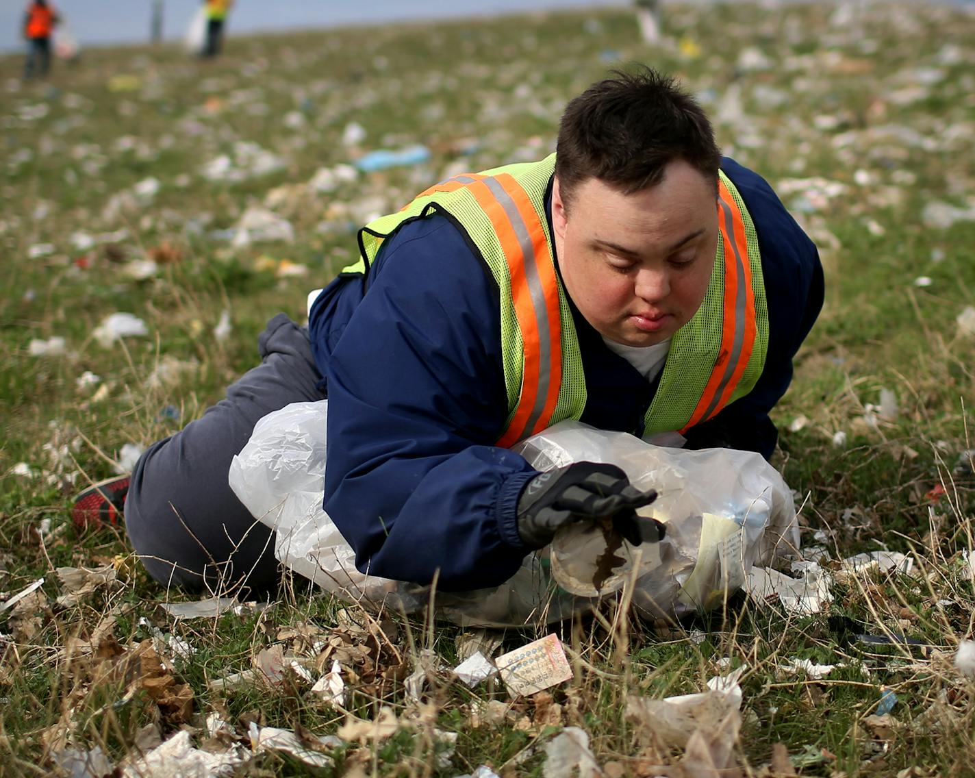 Scott Rhude, 33, sits spread-eagled in a field of garbage, reaching for a piece of trash while on a work assignment with a sheltered workshop "enclave" Tuesday, April 28, 2015, near the landfill in Wilmar, MN. Like many of his coworkers on the cleanup crew, Rhude dreams of landing a &#xec;real job&#xee; in the community. But for that, he would need specialized training, transportation to and from work and access to a job coach.&#xec;He is stuck, stuck stuck,&#xee; said Mary Rhude, Scott&#xed;s m