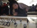 A customer takes a close look at Apple Watches on display in a glass case at an Apple retail store in Beijing, Friday, April 10, 2015. From Beijing to