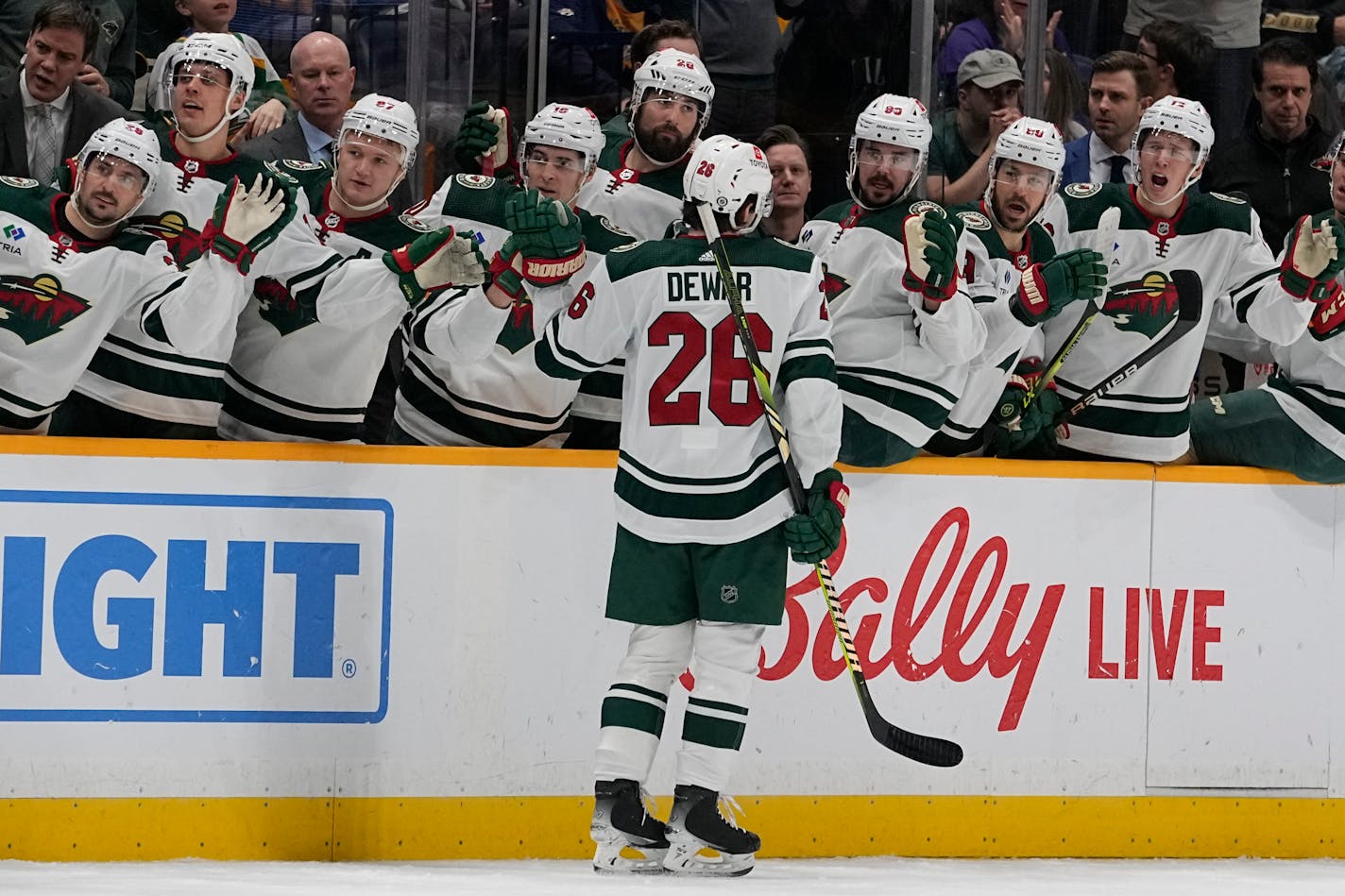 Minnesota Wild center Connor Dewar (26) celebrates a goal with teammates during the first period of an NHL hockey game against the Nashville Predators, Thursday, Nov. 30, 2023, in Nashville, Tenn. (AP Photo/George Walker IV)