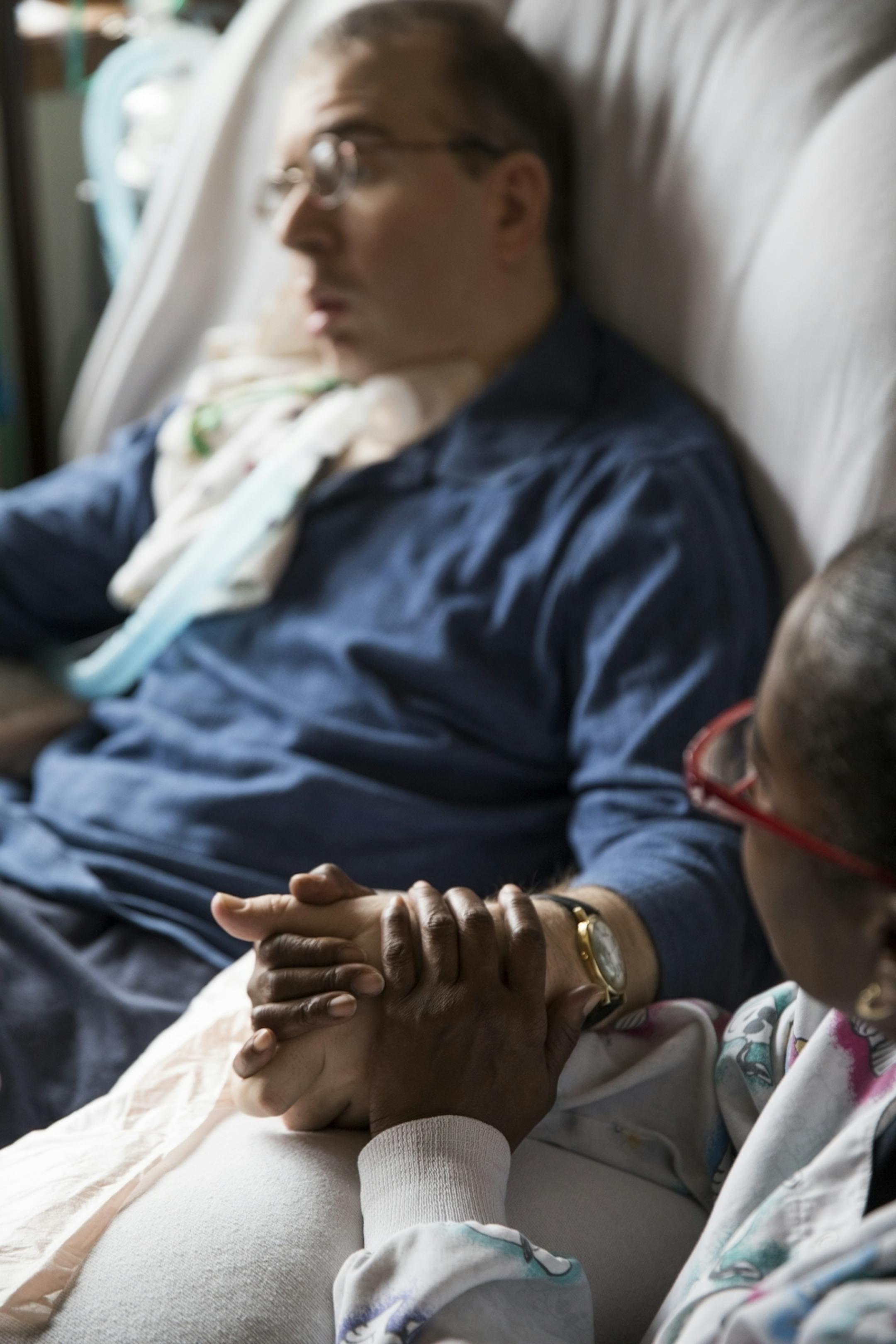 PCA Nora Clark attends to Scott Semo, which sometimes can mean just holding his hand and keeping a very close eye on him.