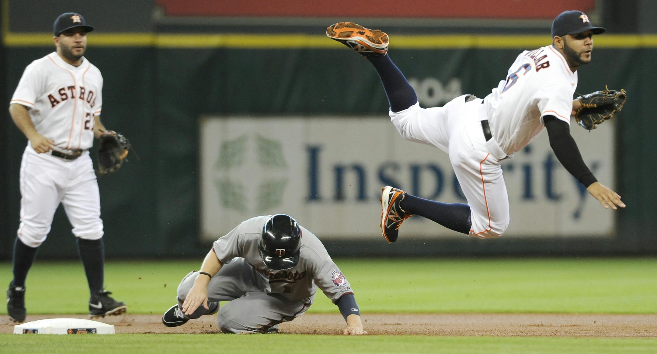 Houston Astros shortstop Jonathan Villar (6) goes airborne over Minnesota Twins' Alex Presley, center, to complete the double play on Twins' Darin Mastroianni as second baseman Jose Altuve (27) looks on in the first inning of a baseball game Wednesday, Sept. 4, 2013, in Houston. (AP Photo/Pat Sullivan)