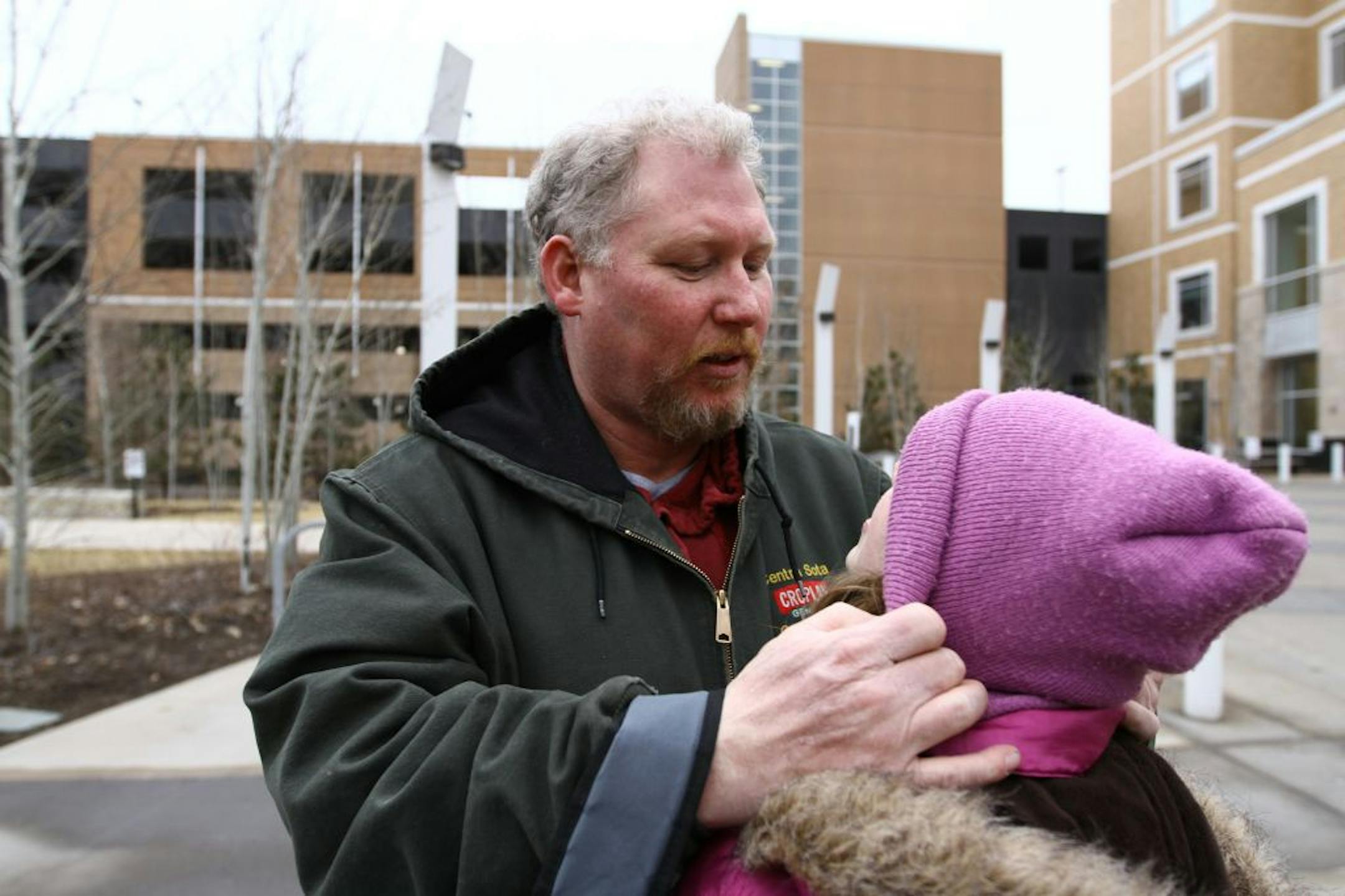 Paul Thielen (cq/source) adjusts his daughter's hat while waiting for her cardiology appointment outside of the Children's Hospital in Minneapolis on Friday, February 3, 2012. Thielen was laid off and because he checked the wrong box on his unemployment application, he hasn't been able to recieve an estimated $1,500 in assistance from the Minnesota Department of Employment and Economic Development.