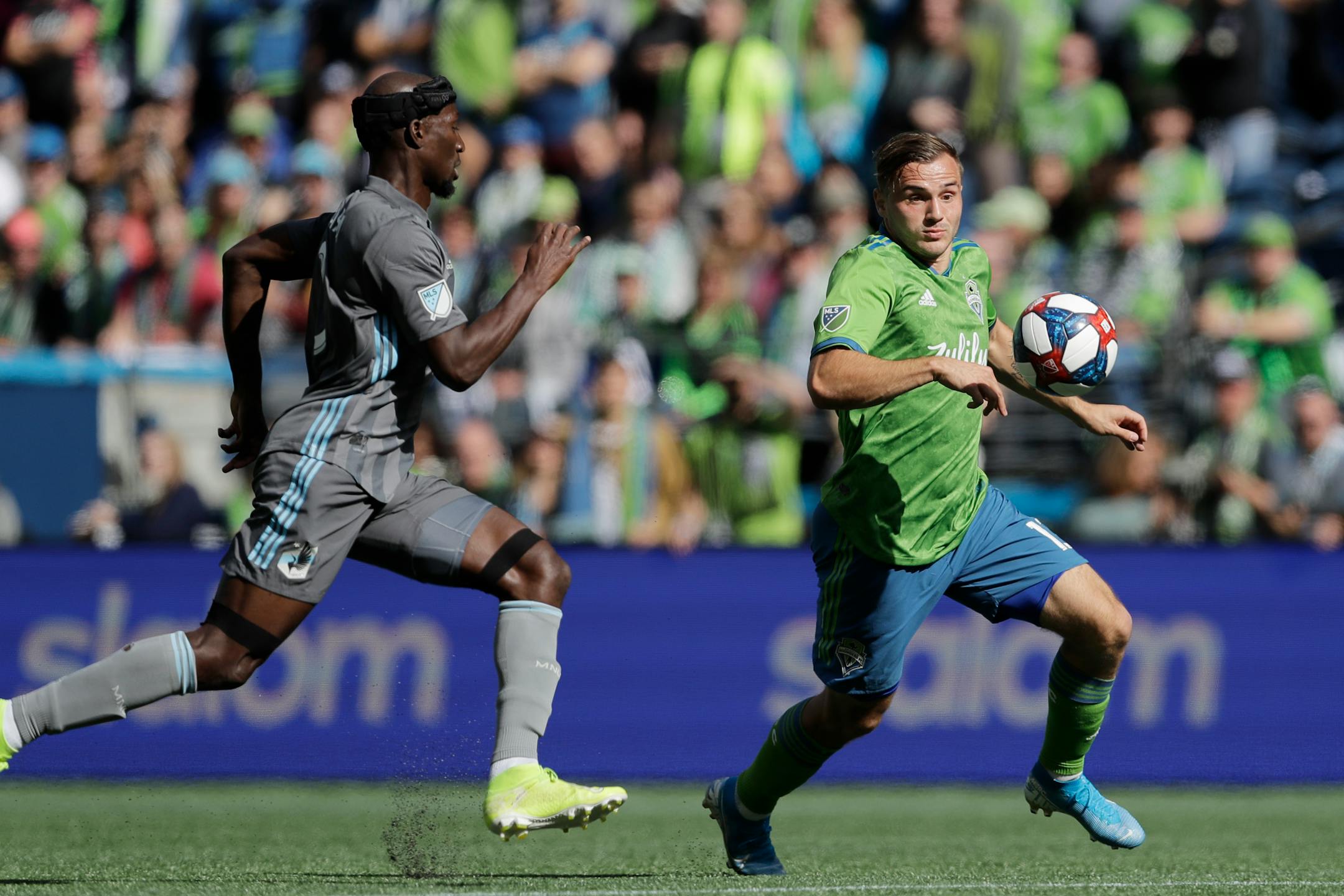 Seattle Sounders forward Jordan Morris, right, eyes the ball as Minnesota United's Ike Opara, left, closes in during the first half