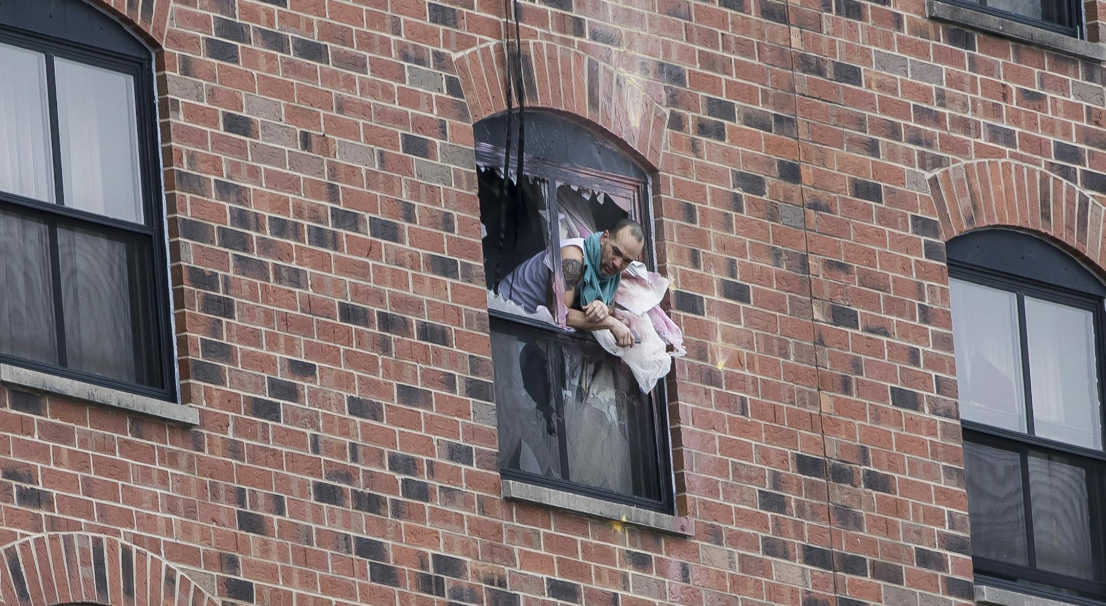 A man leaned out a window where a suspect has been on a stand off with police for over a day on Tuesday, January 30, 2018, at the Graduate Hotel at the University of Minnesota in Minneapolis, Minn. ] RENEE JONES SCHNEIDER ï renee.jones@startribune.com