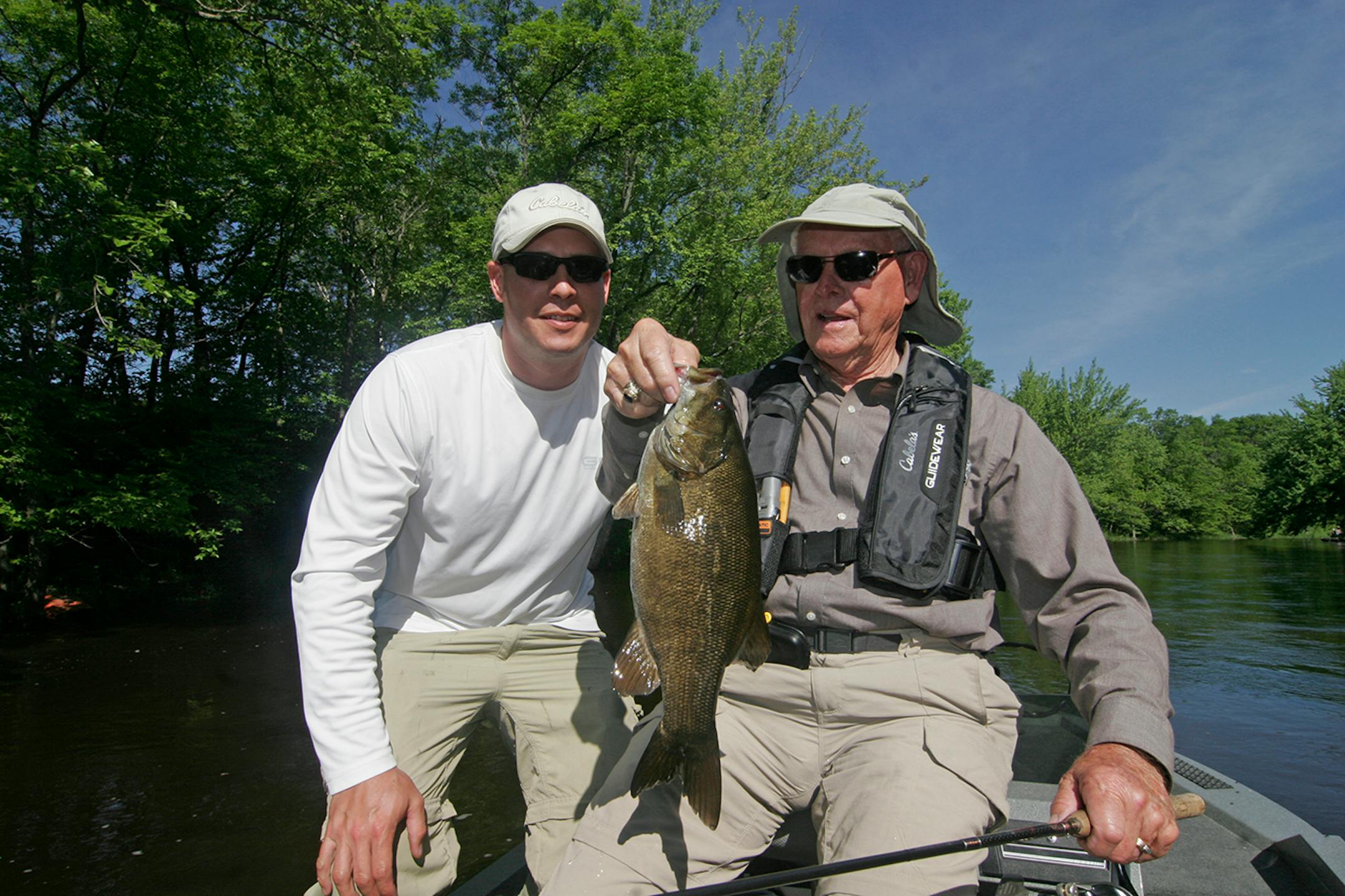 Nate Foster (left), 35, of St. Cloud, a veteran of the wars in Afganistan and Iraq, and his grandfather, Swede Anderson, 82, of Rochester, a veteran of the Korean War, holds a smallmouth bass Anderson caught during the Trolling for the Troops event Friday at Camp Ripley.