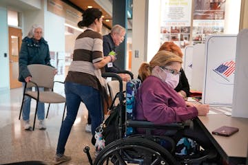 Raven Moe, 26, who has spina bifada, a spinal condition that has left her paralyzed from the waist down and in a wheelchair, fills out a ballot at the