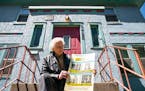 Bill Pagel with a concert poster outside Bob Dylan's old house in Hibbing. Pagel owns both of Dylan's childhood homes along with thousands of other pi