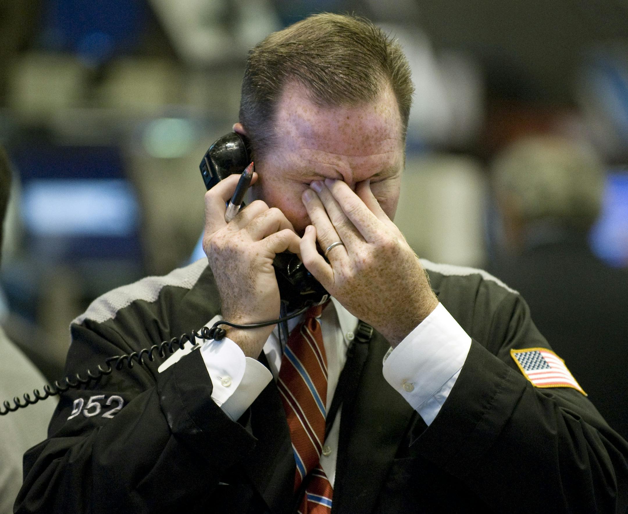 FILE- In this Sept. 17, 2008, file photo trader Christopher Crotty rubs his eyes as he works on the floor of the New York Stock Exchange. Home prices had sunk, and foreclosure notices began arriving. Layoffs began to spike. Tremors intensified as Lehman Brothers, a titan of Wall Street, slid into bankruptcy on Sept. 15, 2008. The financial crisis touched off the worst recession since the 1930s Great Depression. (AP Photo/Richard Drew, File)