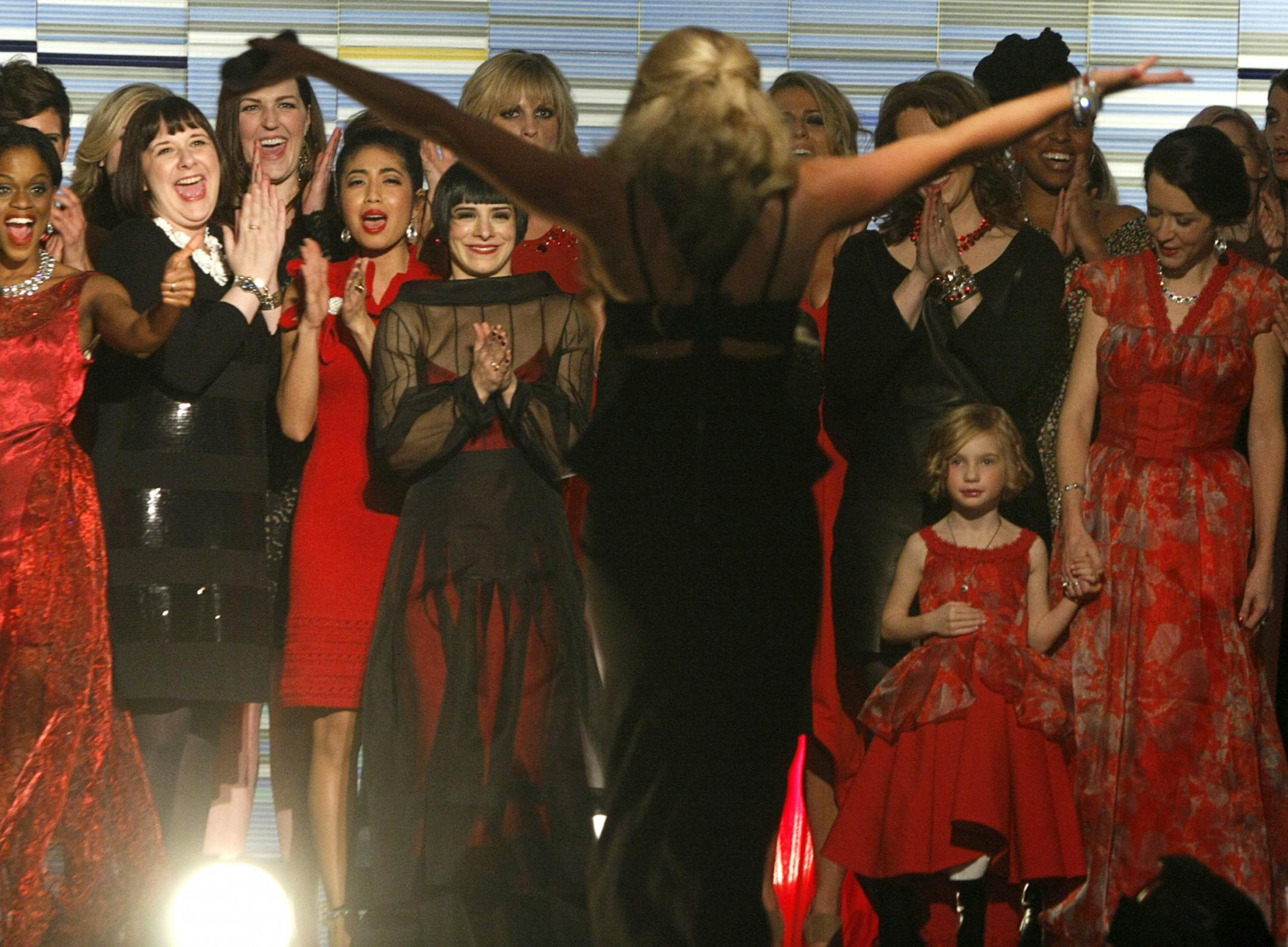 Models and designers applaud host and producer Carly Aplin at the end of the Red Dress Collection fashion show at the Graves 601 hotel on Sunday, February 16, 2014.