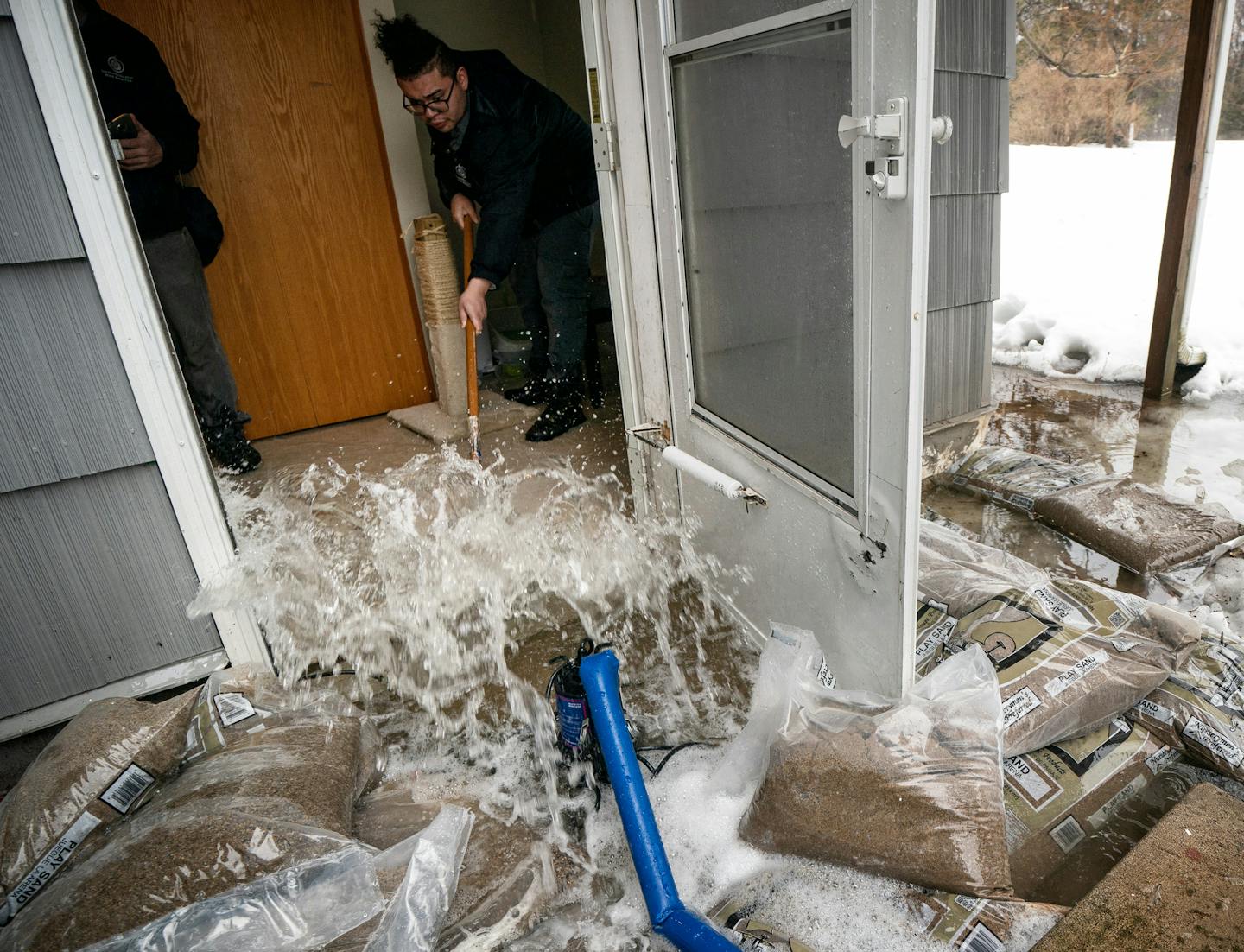 Josue Huerta of Service Restoration squeegeed a few inches of water from a flooded basement caused by rain and melting snow in the west-metro suburbs.