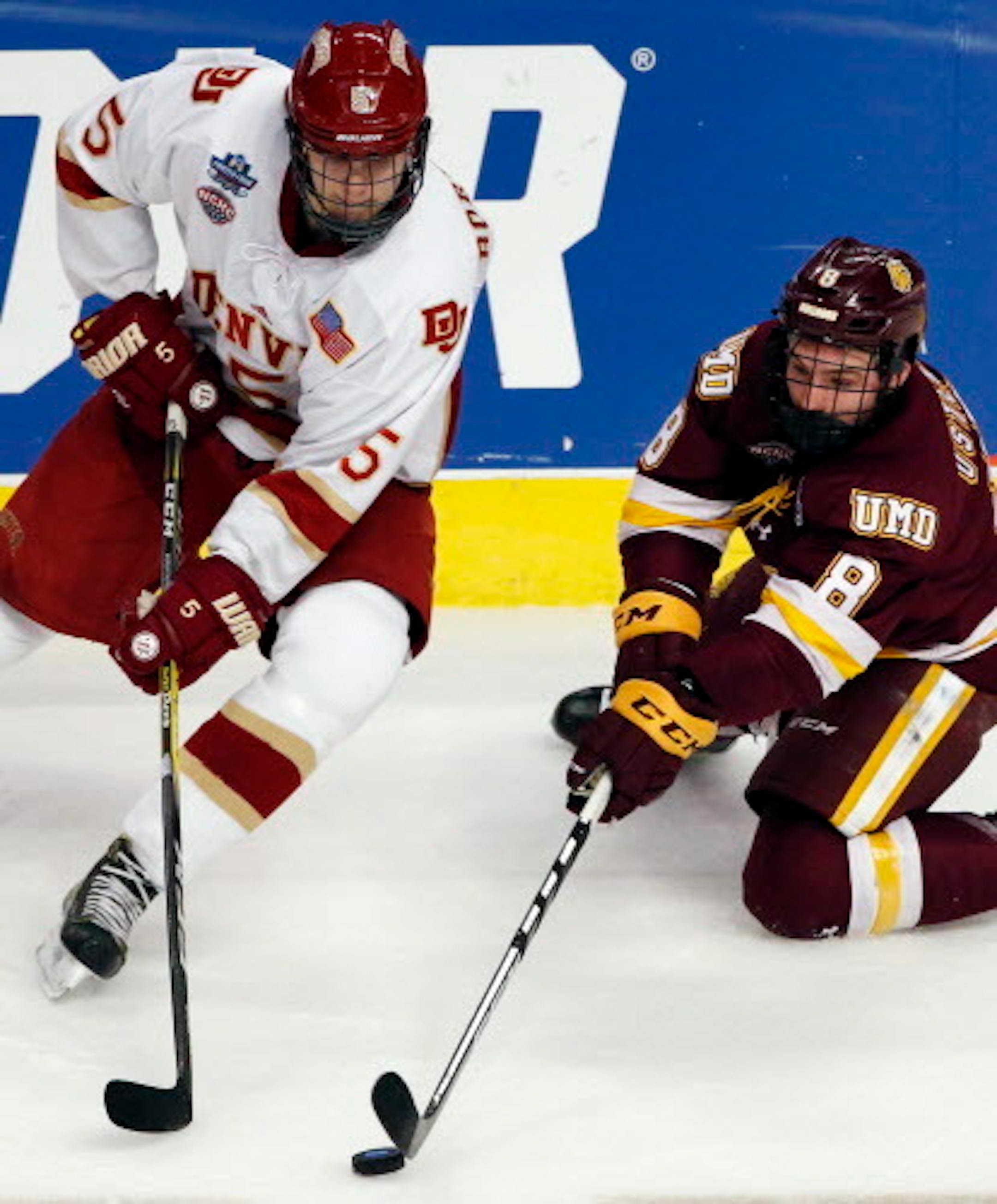 Minnesota-Duluth left wing Kyle Osterberg, right, controls the puck against Denver center Henrik Borgstrom during the first period of an NCAA Frozen Four championship college hockey game, Saturday, April 8, 2017, in Chicago. (AP Photo/Nam Y. Huh)