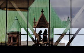 City Hall is reflected in a skyway in downtown Minneapolis.