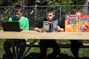 In Owatonna, MN on May 12, 2021, the Hadt siblings Carter,11, Riley,14(green), and Abigail,7, take advantage of the weather to read outside.] Andrew a