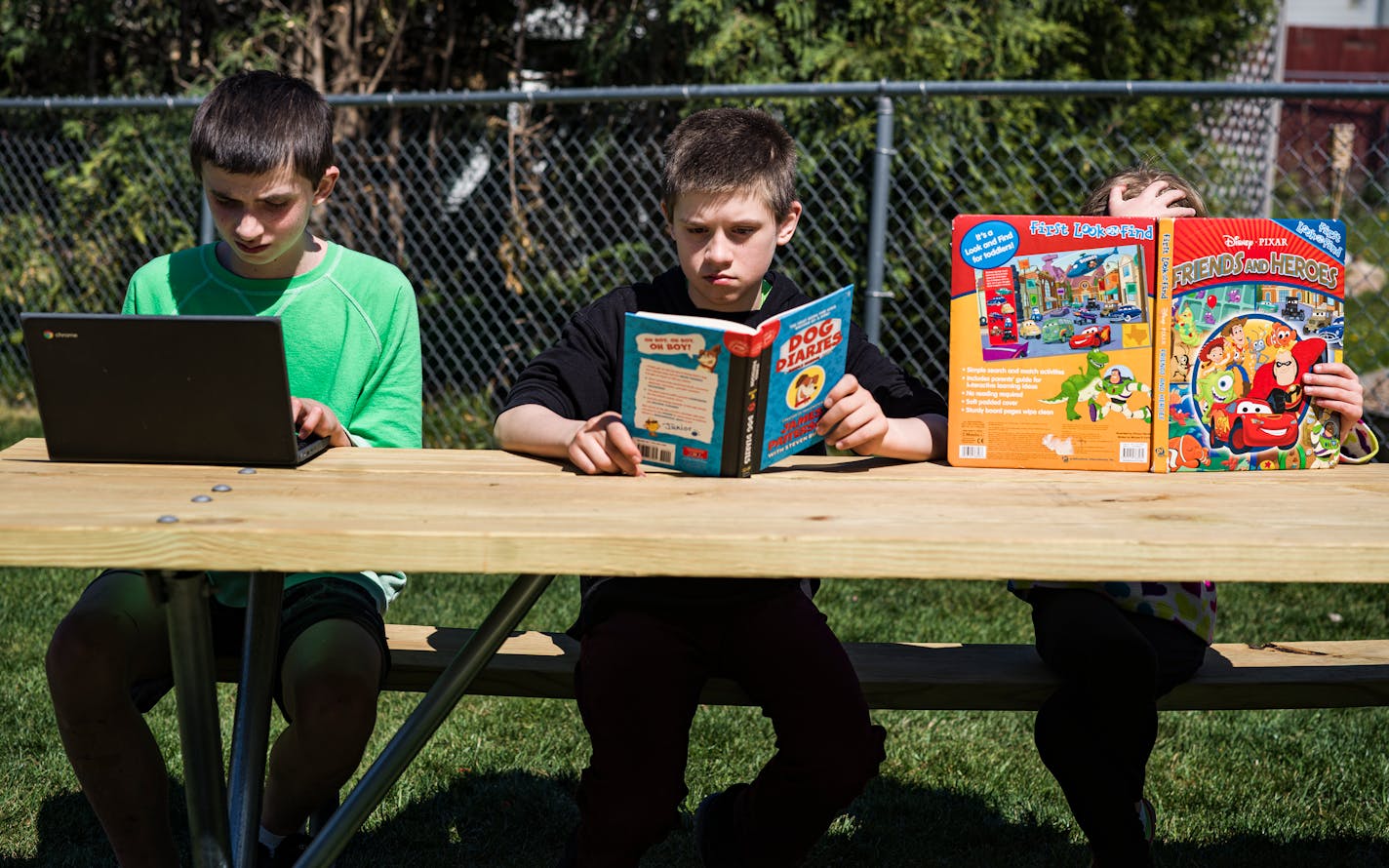 In Owatonna, MN on May 12, 2021, the Hadt siblings Carter,11, Riley,14(green), and Abigail,7, take advantage of the weather to read outside.] Andrew and Stacy Hadt and their three children will be at home during a day of online learning. The family has had a great experience with distance learning this year and are opting to enroll in their district's new online academy next year as a result. Kids are Riley, Carter and Abby. RICHARD TSONG-TAATARII ¥ Richard.Tsong-Taatarii@startribune.com