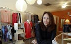 In this April 24, 2015 photo, Razzle Dazzle dress shop owner Carol Avendano poses at her store in the Buckhead section of Atlanta. Razzle Dazzle's rev
