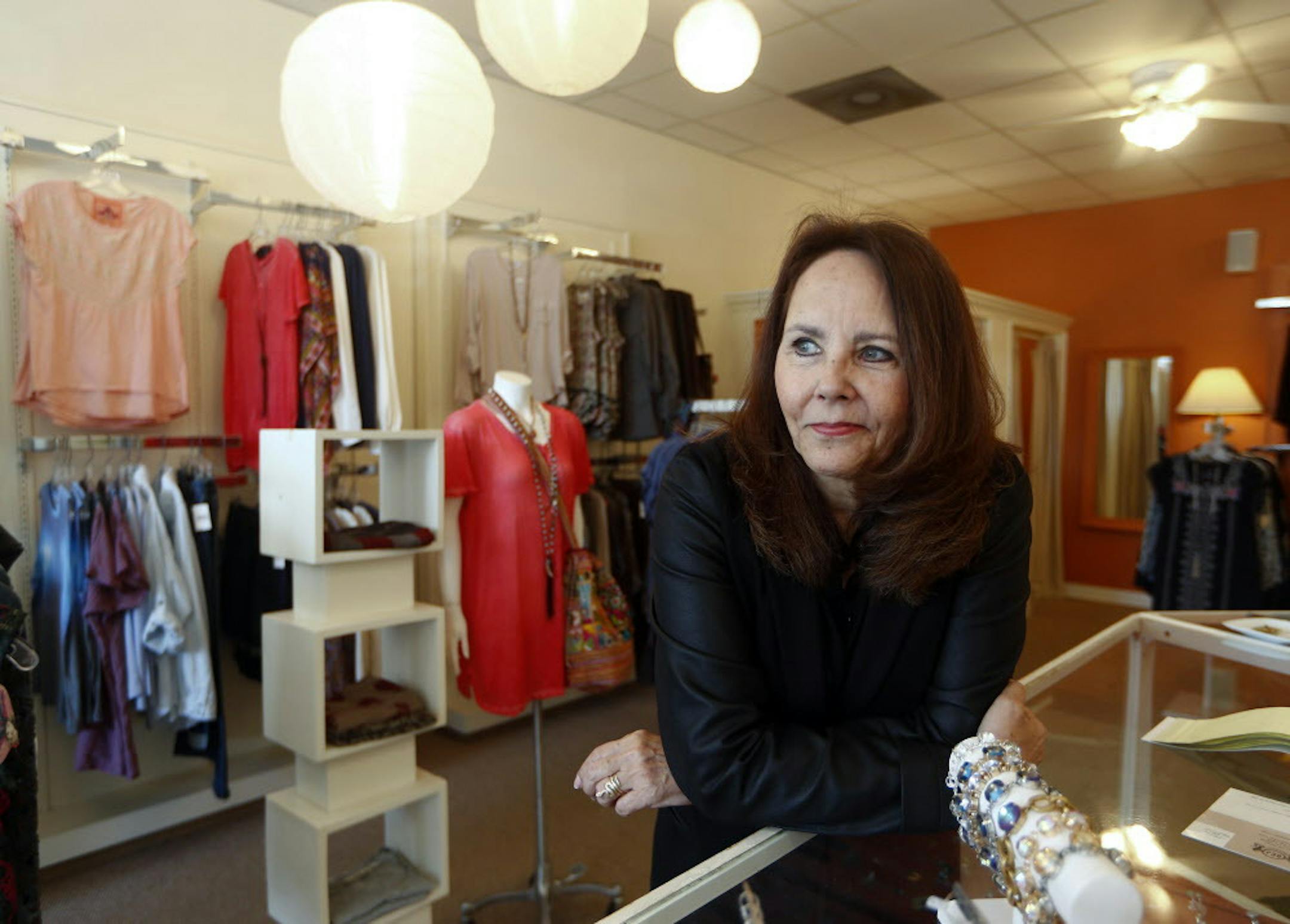 In this April 24, 2015 photo, Razzle Dazzle dress shop owner Carol Avendano poses at her store in the Buckhead section of Atlanta. Razzle Dazzle's revenue is down 65 percent from 2007. Avendano sees customers think carefully before spending. (AP Photo/John Bazemore)