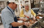 Arlene Leyden and Paul Sederstom, volunteers at Dorothy Day Center in downtown St. Paul, help carve 18 turkeys for the final Thanksgiving meal at the 