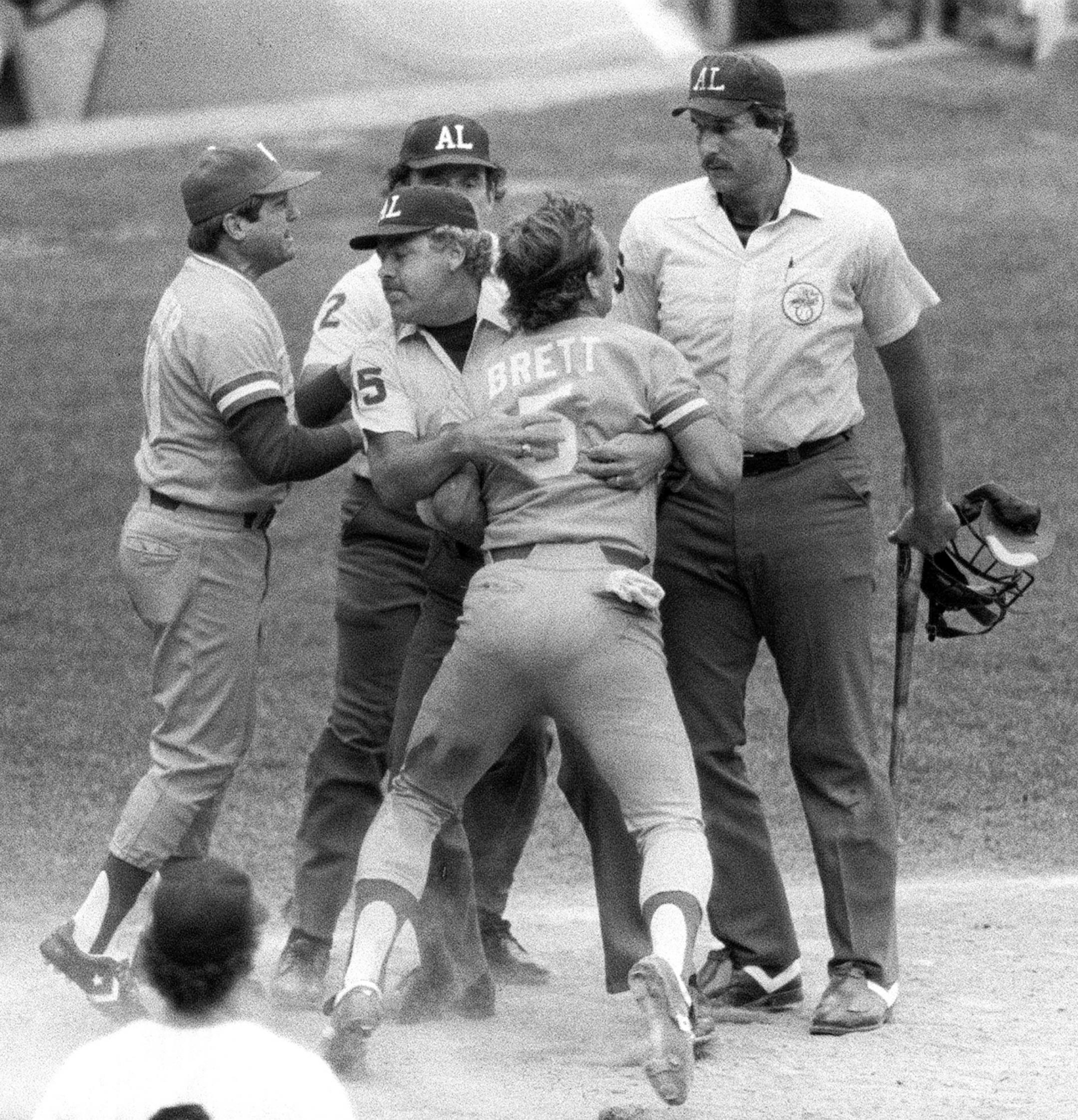 George Brett was restrained by Joe Brinkman after his bat, held by Tim McClelland, was ruled illegal on July 24, 1983.