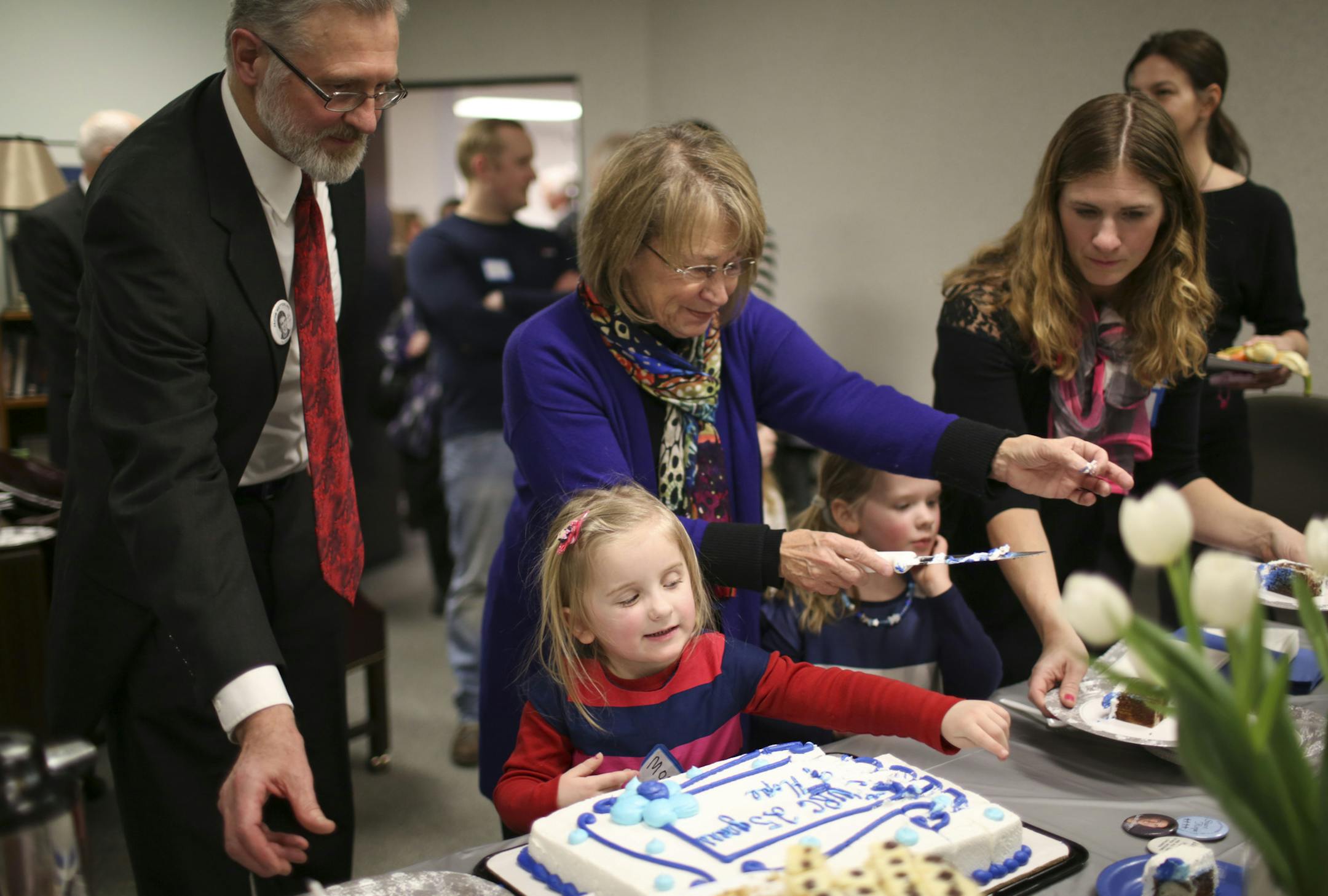 Patty Wetterling cut a cake during the open house at the Jacob Wetterling Resource Center Tuesday afternoon. With her were her husband, Jerry, daughter Carmen and twin granddaughters Maizie, foreground, and Belle. ] JEFF WHEELER • jeff.wheeler@startribune.com On Jacob Wetterling's 37th birthday, Tuesday, February 17, 2015, his mother and father, Patty and Jerry Wetterling, attended an open house and spoke at the Jacob Wetterling Resource Center to commemorate the organization's 25th anniv