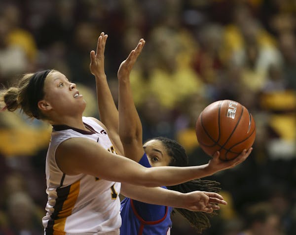 Gophers guard Rachel Banham (1) made a shot from behind the backboard while defended by Southern Methodist Mustangs guard Keena Mays (23) in the first