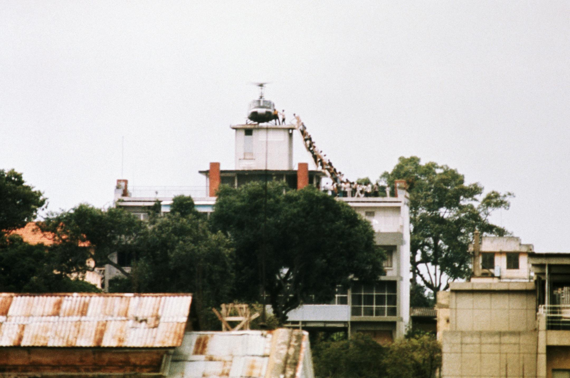 A CIA employee (probably O.B. Harnage) helps Vietnamese evacuees onto an Air America helicopter from the top of 22 Gia Long Street, a half mile from the U.S. Embassy. (Copyright Bettmann/Corbis / AP Images) ORG XMIT: BE001049