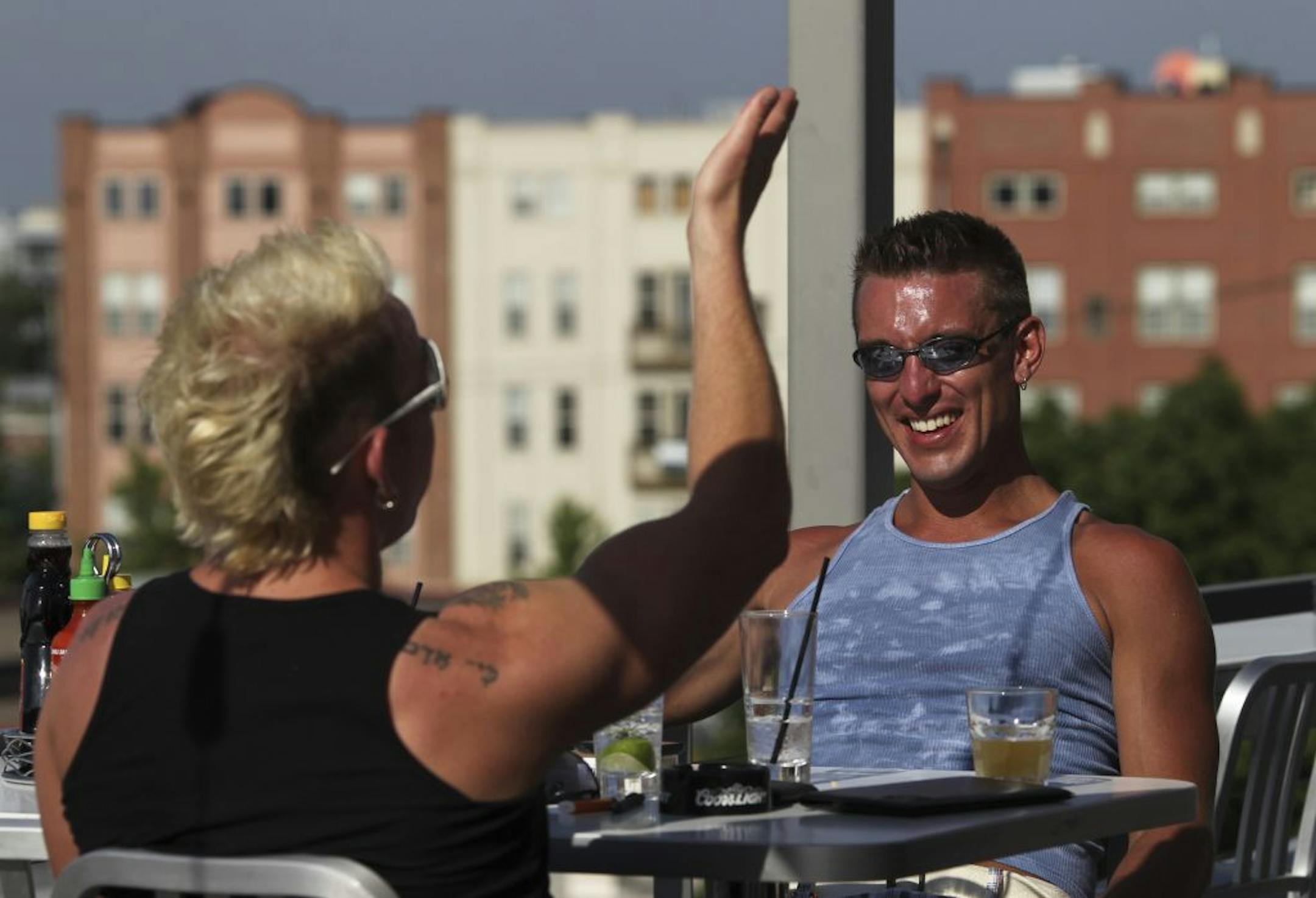 Justin Hamblen, left, and Chris Mellgren chatted over a drink early Monday evening at the rooftop Sky Bar of the Uptown Cafeteria and Support Group in Minneapolis.
