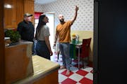 Realtor Kent Sandness, left, and his clients Joey and Kenzie Mandelko look at a kitchen during an open house Wednesday, April 10, 2024 in Minneapolis,