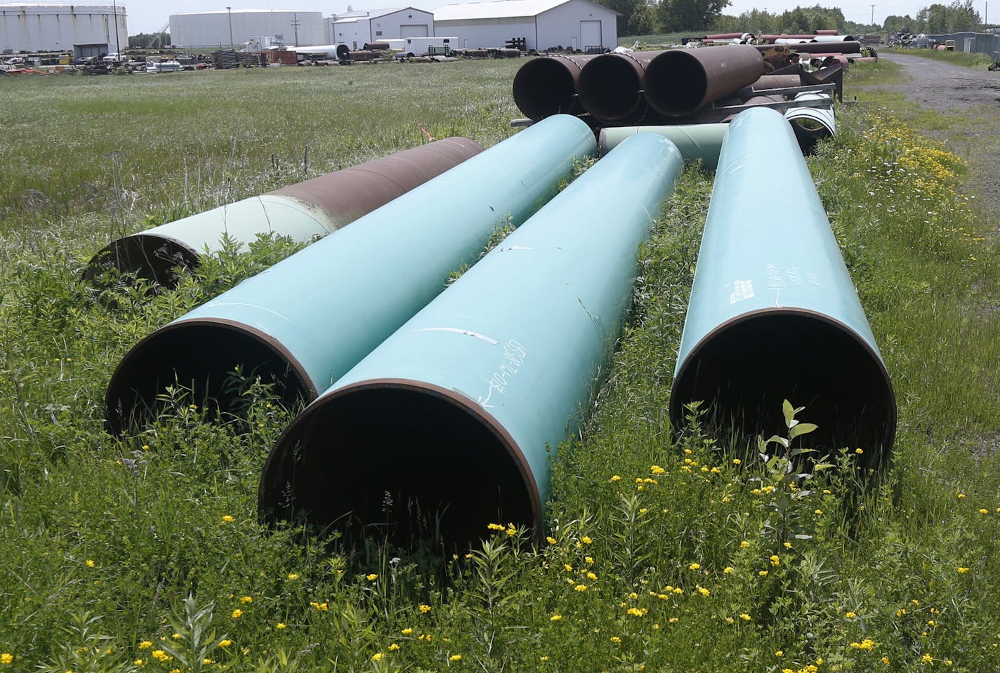 Enbridge is still awaiting approvals to build the Minnesota portion of a new pipeline the would carry oil from Alberta, Canada, to Superior, Wis. This 2018 photo shows a storage site for the pipes. (AP Photo/Jim Mone, File)