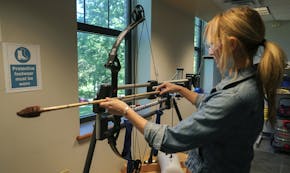 In this June 1, 2017, photo, Michelle Bebber, a PhD archeology student at Kent State University, loads a bow with a recreated ancient arrow in Kent, O