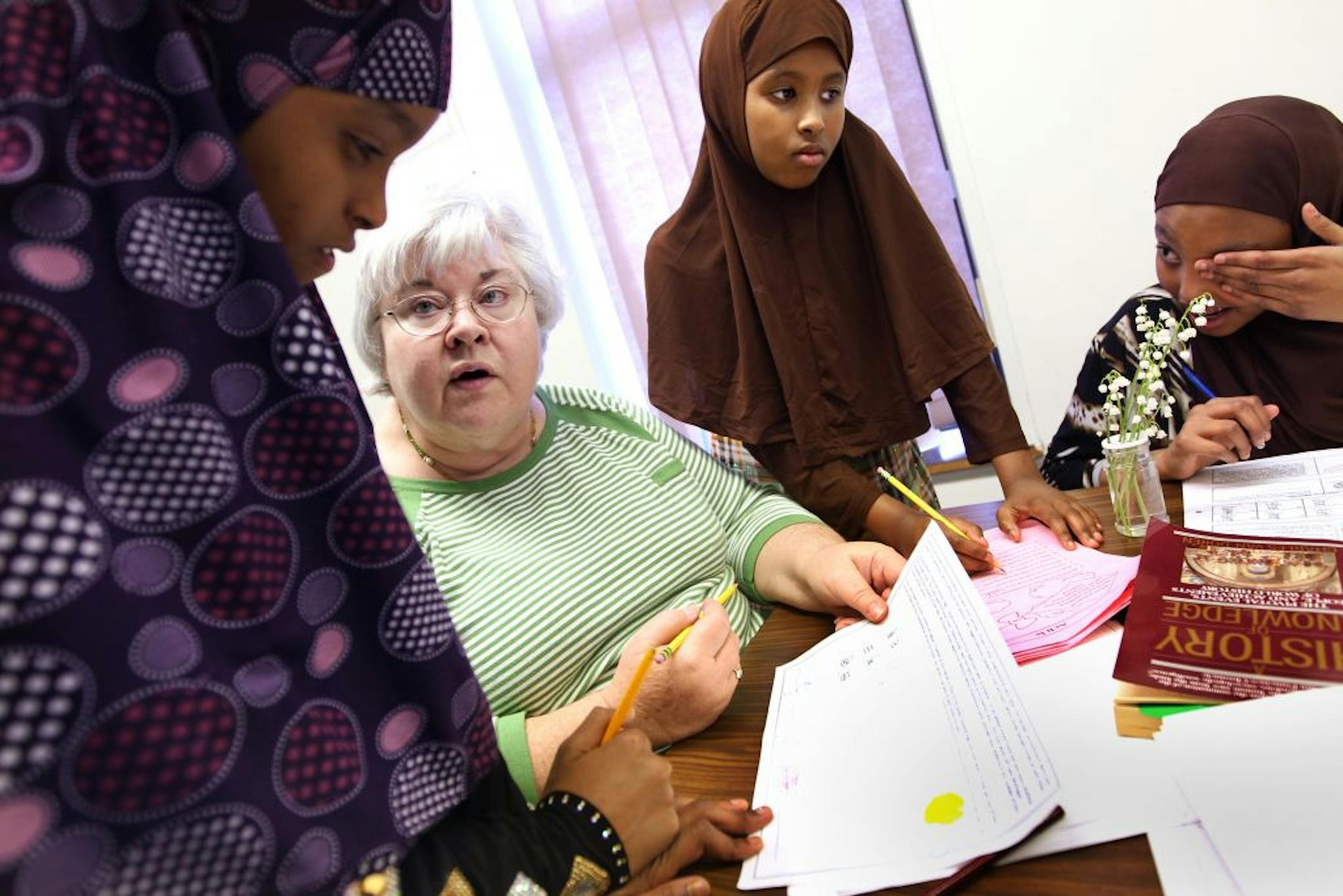 Volunteer tutor Carolyn Korbel, second from left, helps, left to right, Subeyda Salah, Suhur Salah, and Nasteho Abdullahi with homework during after-school tutoring at the New American Academy in Edina May 8, 2012. The Salah sisters attend Cedar Ridge Elementary School in Eden Prairie, and Nasteho attends Eden Lake Elementary School in Eden Prairie.