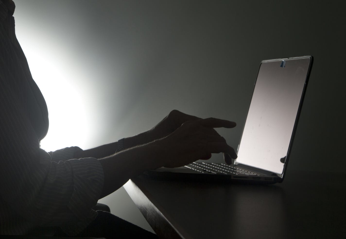 FILE - In this, Monday, Dec. 12, 2016, file photo illustration, a person types on a laptop, in Miami. A new Pew Research Center study says a whopping 41 percent of U.S. adults have experienced online harassment, ranging from offensive name-calling to stalking and sexual harassment. (AP Photo/Wilfredo Lee)